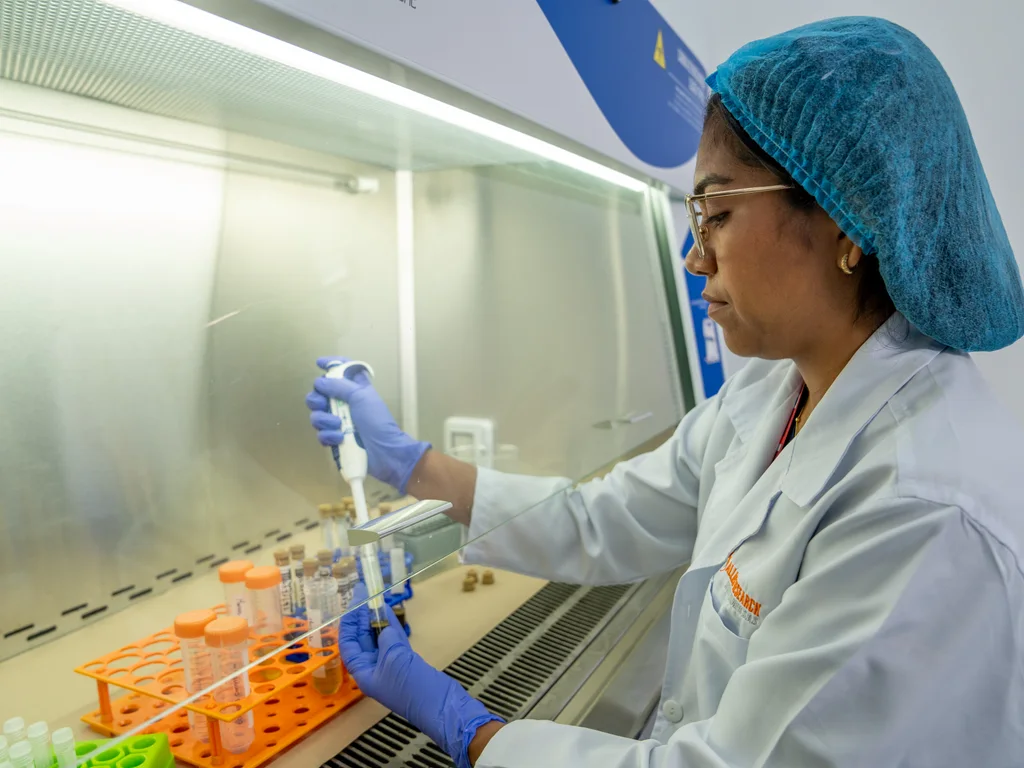 Laboratory professional working with a pipette and tubes in an Allied biosafety cabinet.