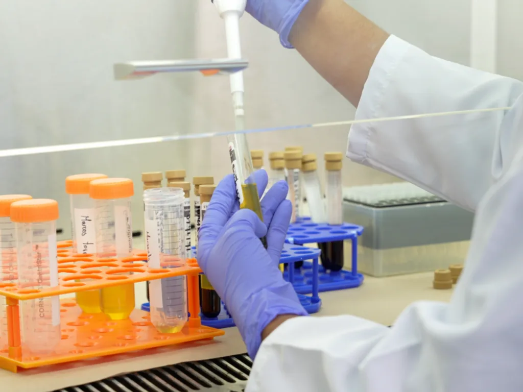 Allied laboratory professional using a pipette inside a biosafety cabinet.